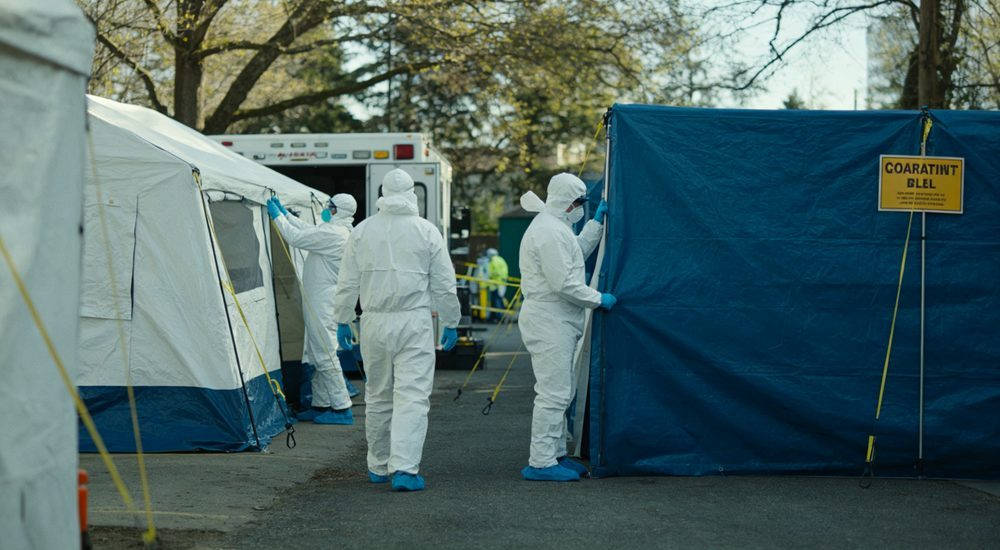 Disease control workers in medical coveralls setting up quarantine zone, emergency response Disease control workers in medical coveralls setting up quarantine zone, emergency response
