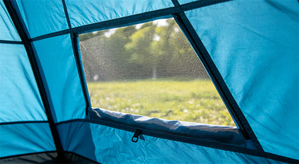 Close-up detail of outdoor relief frame tent mesh window in blue showing insect screen ventilation window with fabric ties and zipper detail