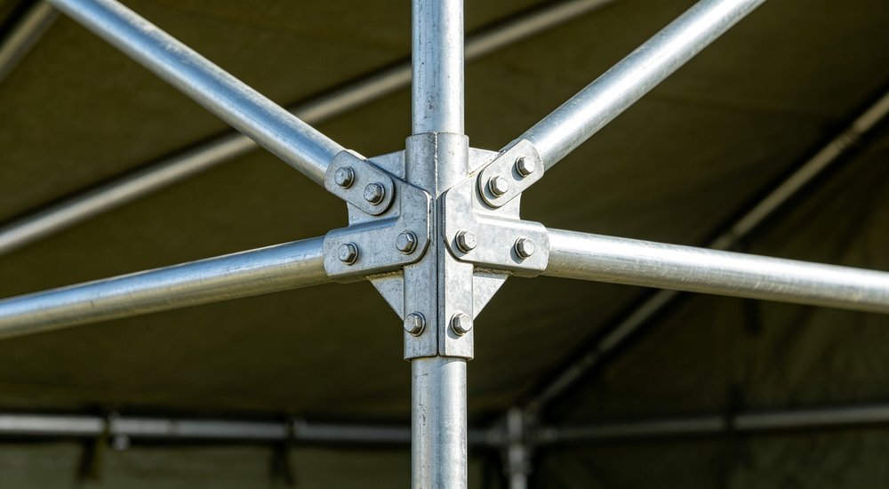 Close-up detailed view of galvanized steel frame structure connection joints of military tent, metal poles with bolts, professional engineering photography, industrial detail