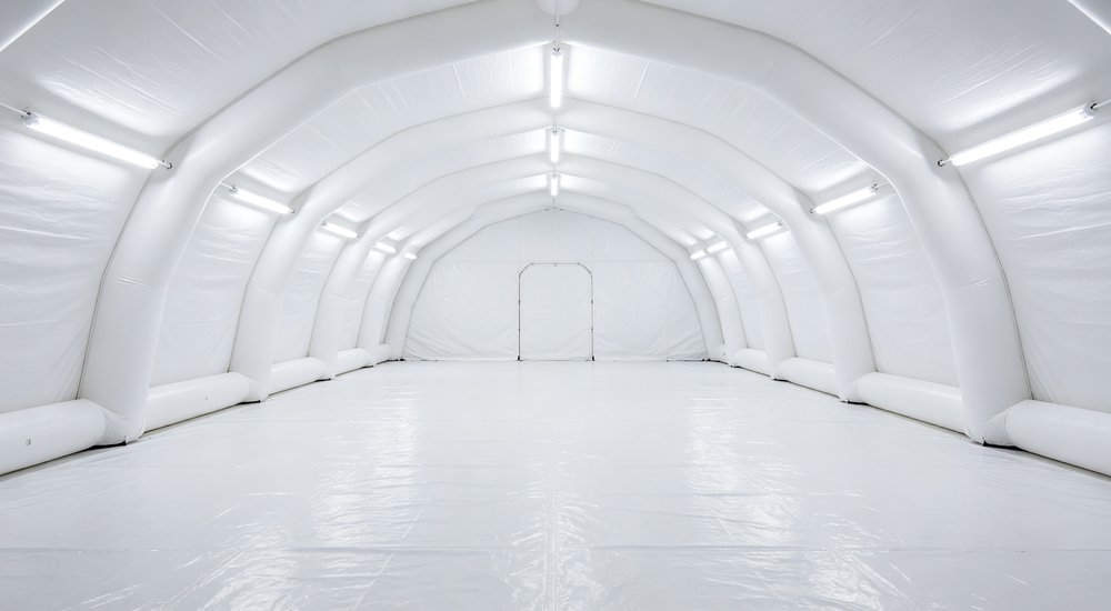 Inflatable tent interior showing open space without poles, bright lighting red and white inflatable emergency shelter for disaster relief operations