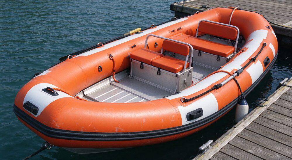 Professional inflatable rescue boat with imported heavy-duty PVC fabric and dual-color wear-resistant tubes floating on calm river ready for immediate emergency deployment by professional teams