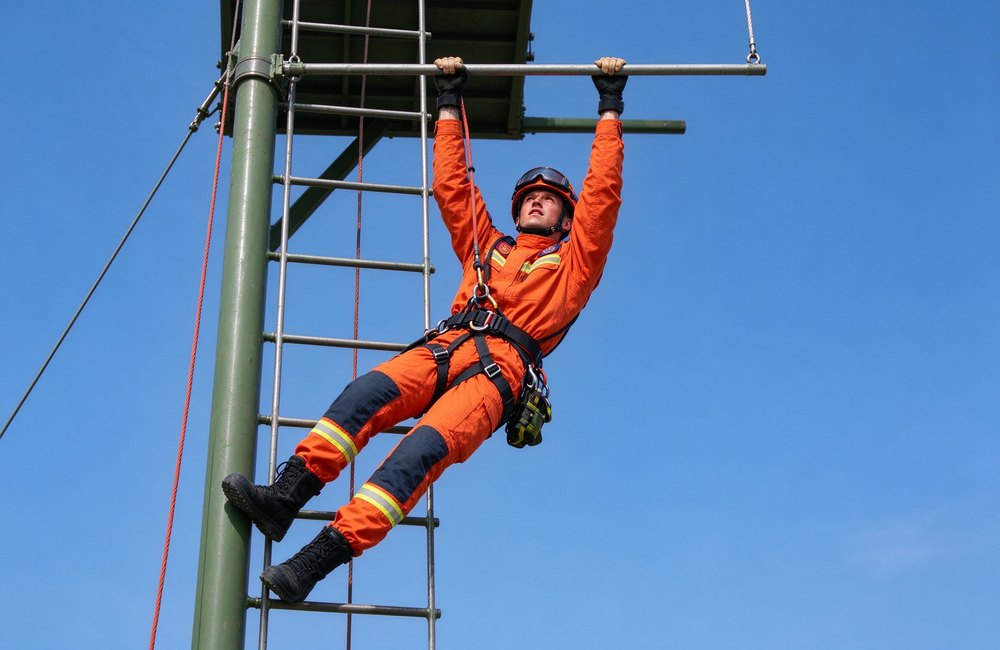 High-angle view of rescuer climbing and crawling in rescue suit for technical orange with yellow reflective trim rescue clothing mobility and rescue clothing unrestricted movement in rescue scenarios