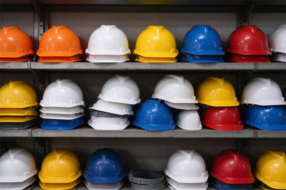 Safety helmets multiple colors on rack: orange white yellow blue red, volcano rescue PPE for emergency operations Safety helmets multiple colors on rack: orange white yellow blue red, volcano rescue PPE for emergency operations