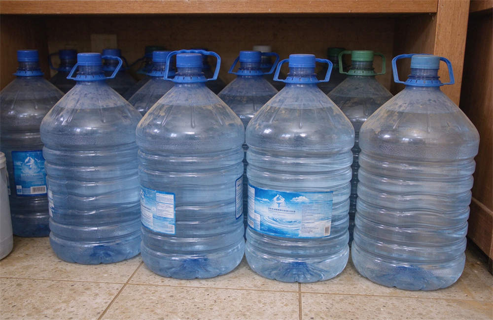 Emergency clean water storage jugs for sandstorm preparedness, bottled water supply for desert disaster relief
